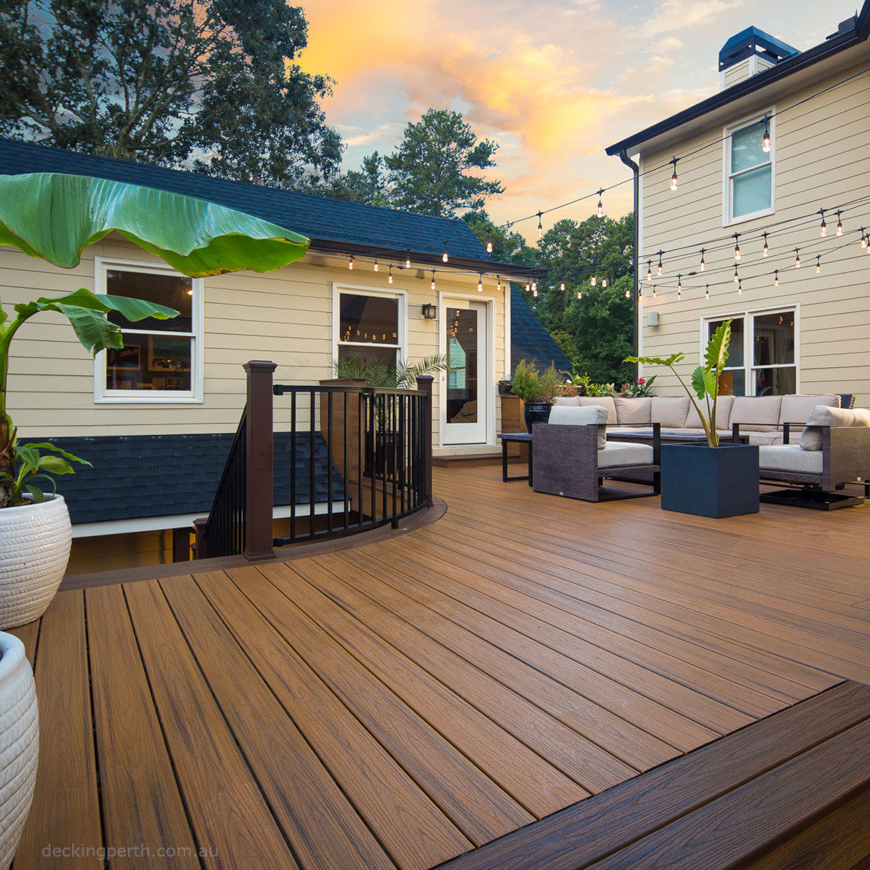 Wooden deck with outdoor furniture and house in the background